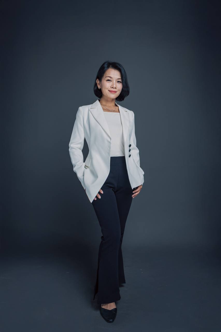 宇宙媽媽賞身穿白色西裝外套與黑色長褲，雙手插在口袋的全身照